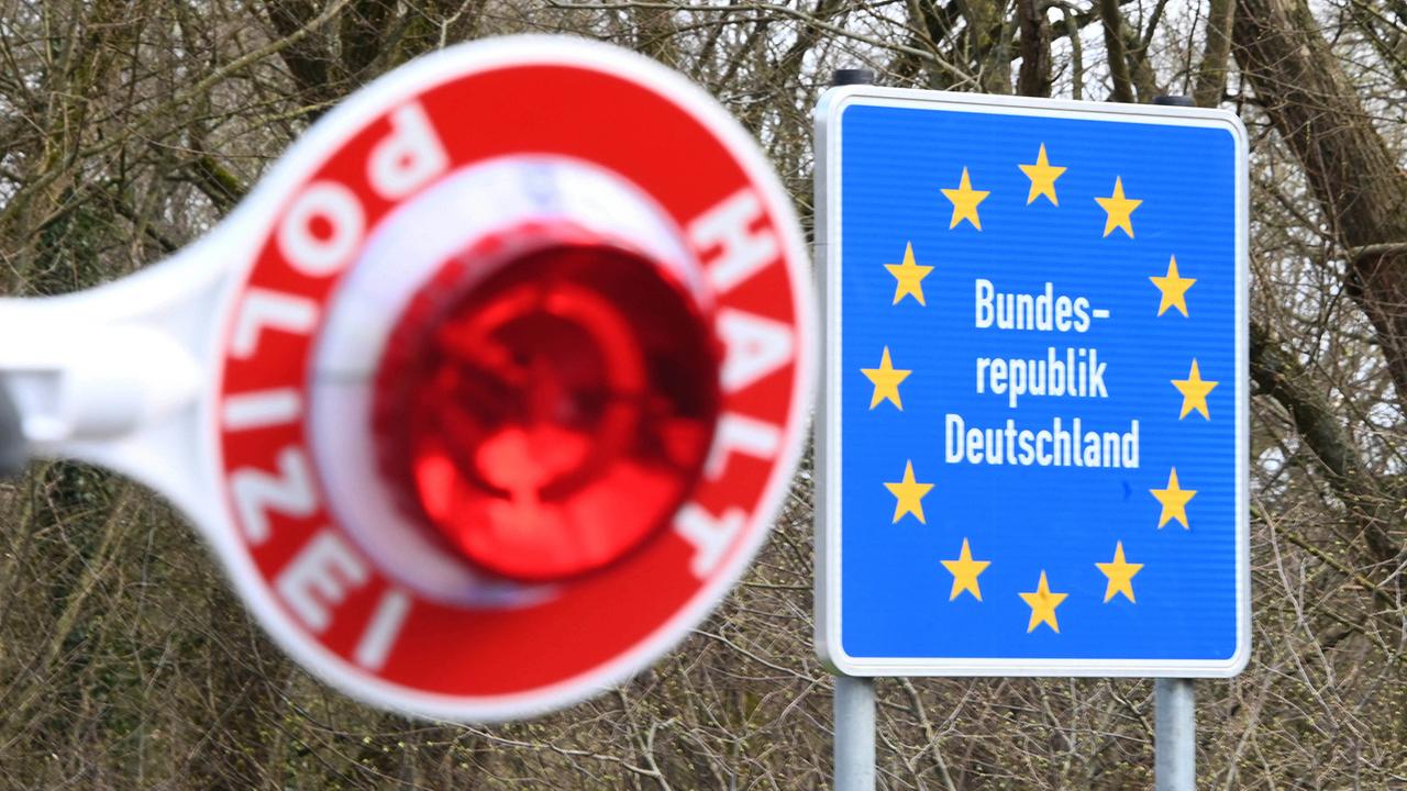 Rote Polizeikelle vor einem Grenzschild zu Deutschland (Foto: picture alliance/dpa | Uli Deck)